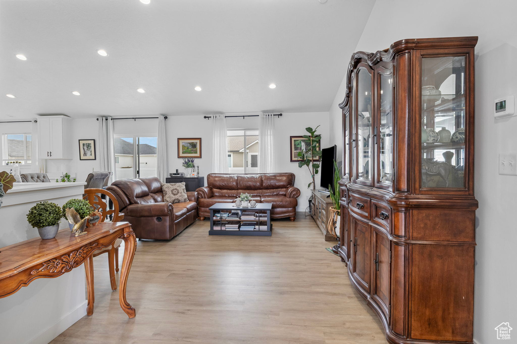 Living room with light wood-style flooring and recessed lighting