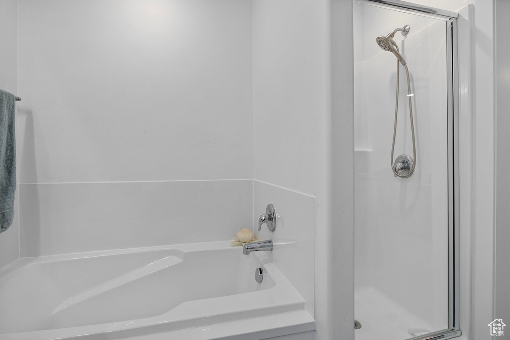 Bathroom featuring a shower with shower door and a tub