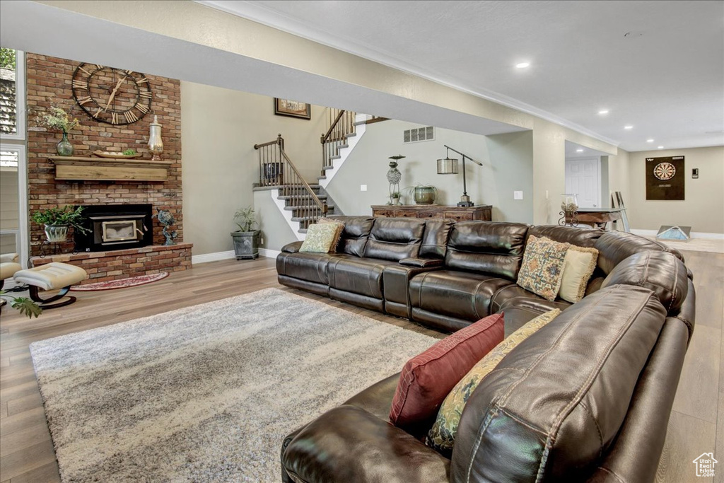 Living area featuring wood finished floors, stairway, crown molding, recessed lighting, and baseboards