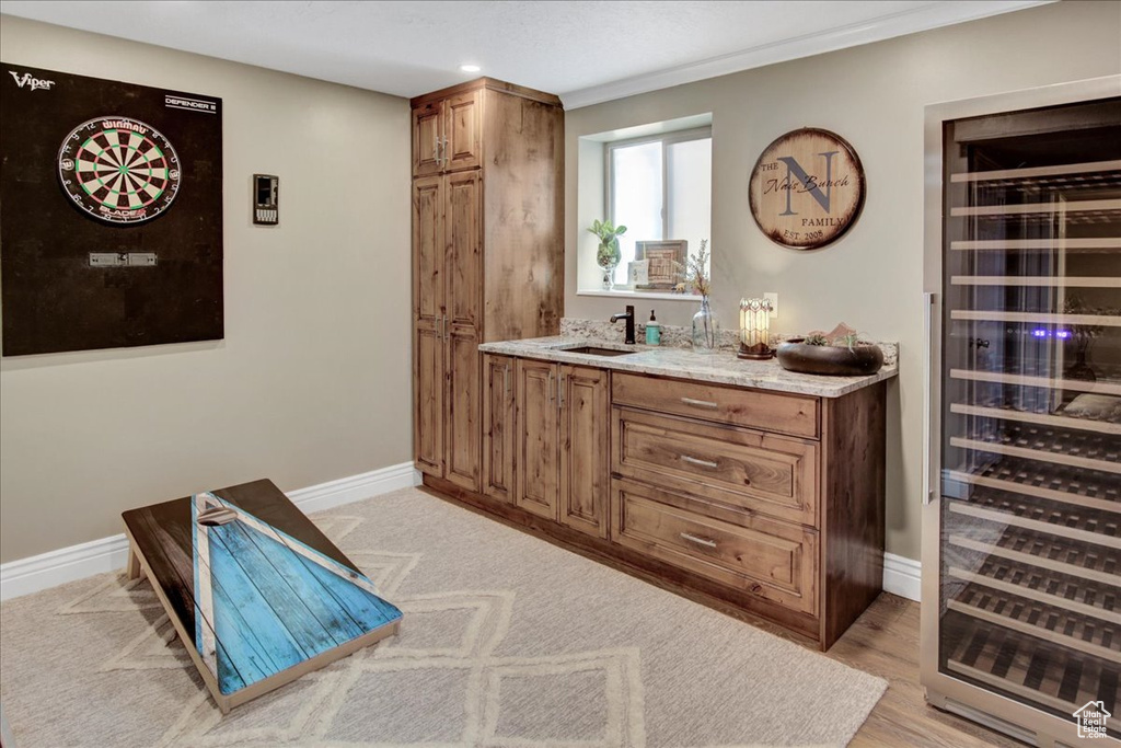 Indoor wet bar with wine cooler, baseboards, and recessed lighting