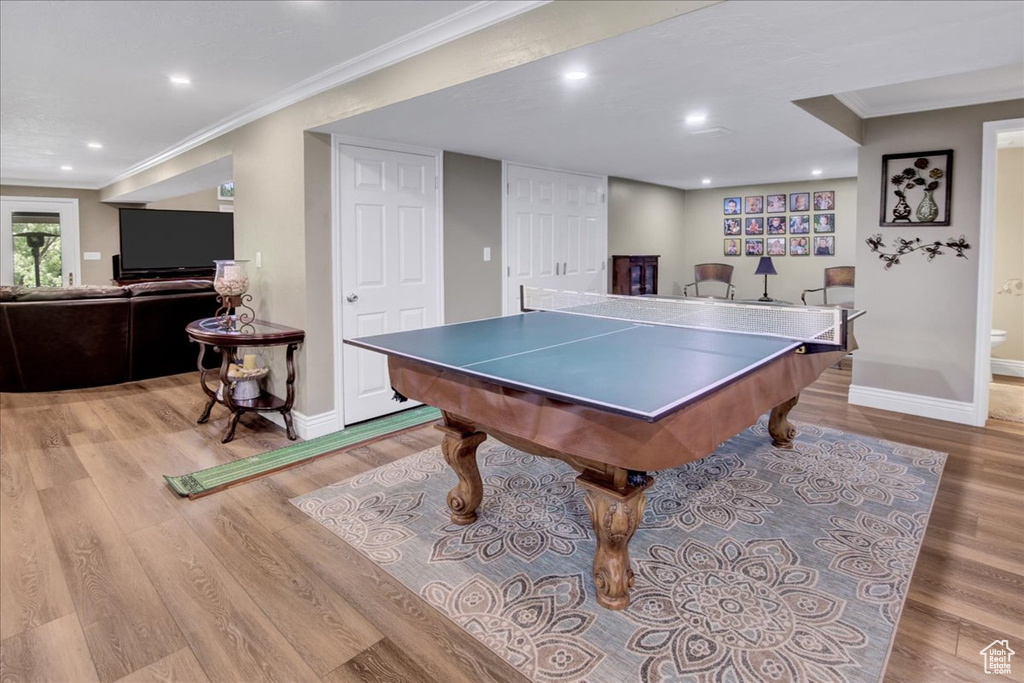 Game room featuring crown molding, wood finished floors, baseboards, and recessed lighting