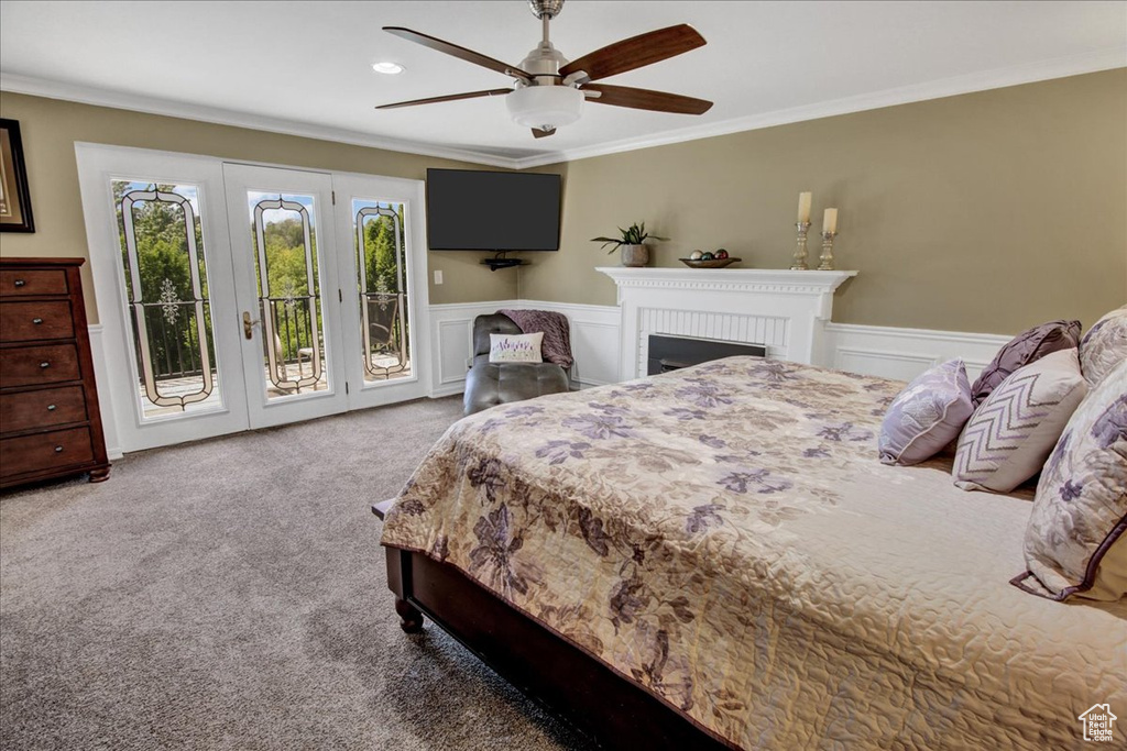 Bedroom with access to exterior, carpet, ornamental molding, wainscoting, and a ceiling fan