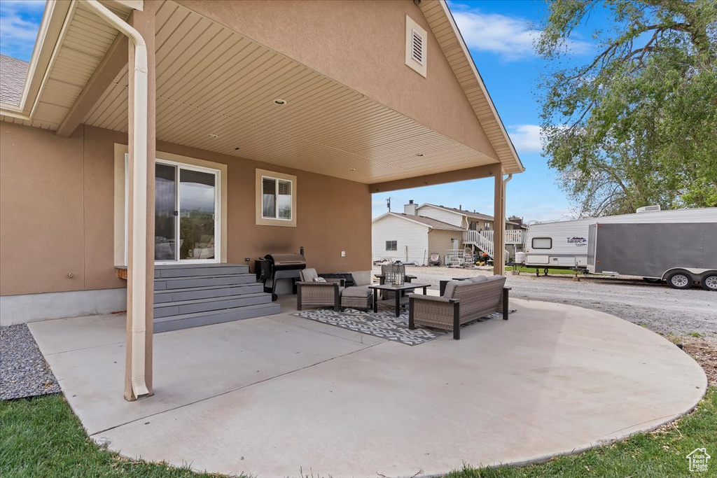 View of patio featuring an outdoor hangout area, entry steps, and grilling area