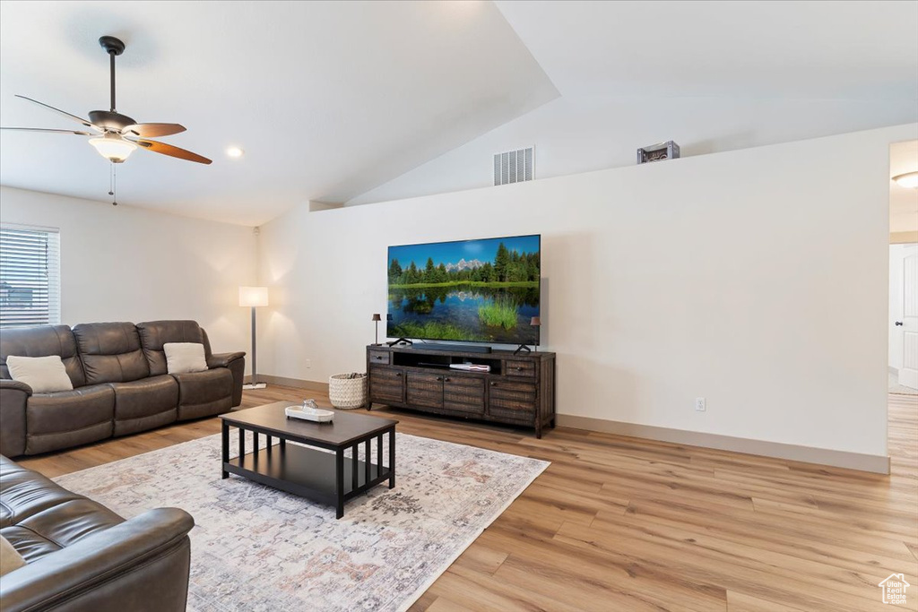 Living area with a ceiling fan, light wood-style flooring, baseboards, and high vaulted ceiling