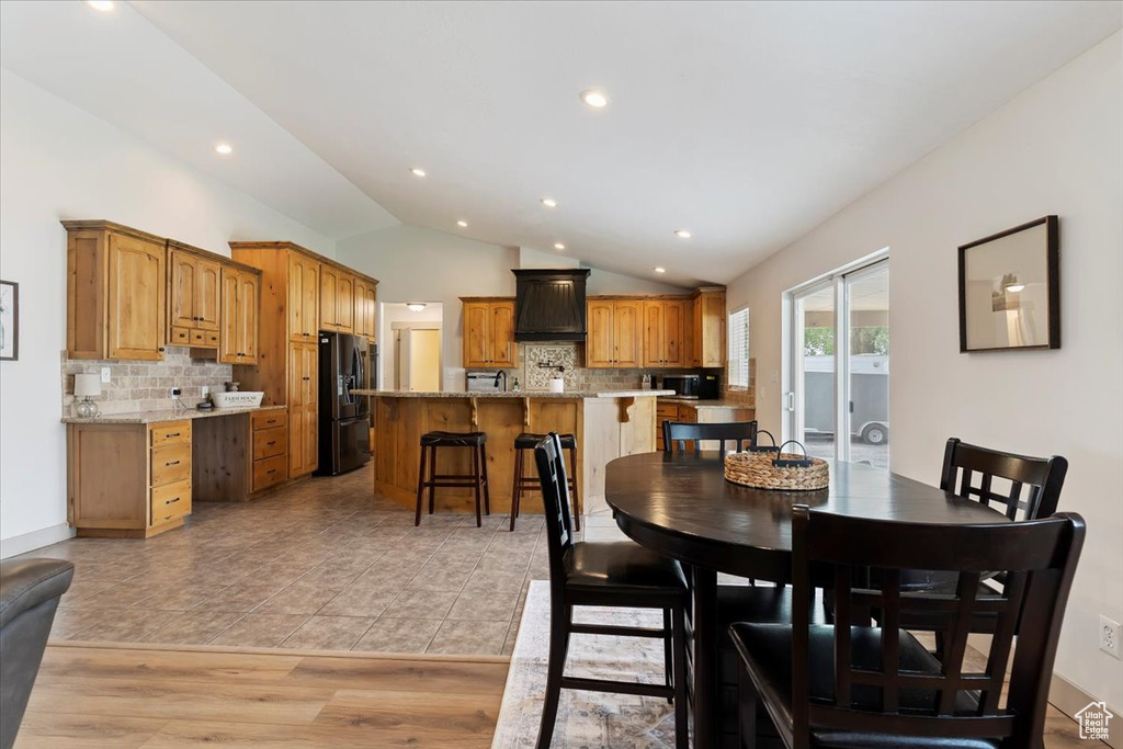 Dining area with vaulted ceiling and recessed lighting