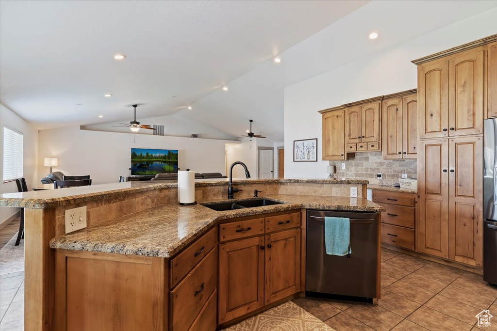 Kitchen featuring appliances with stainless steel finishes, a sink, a ceiling fan, open floor plan, and lofted ceiling
