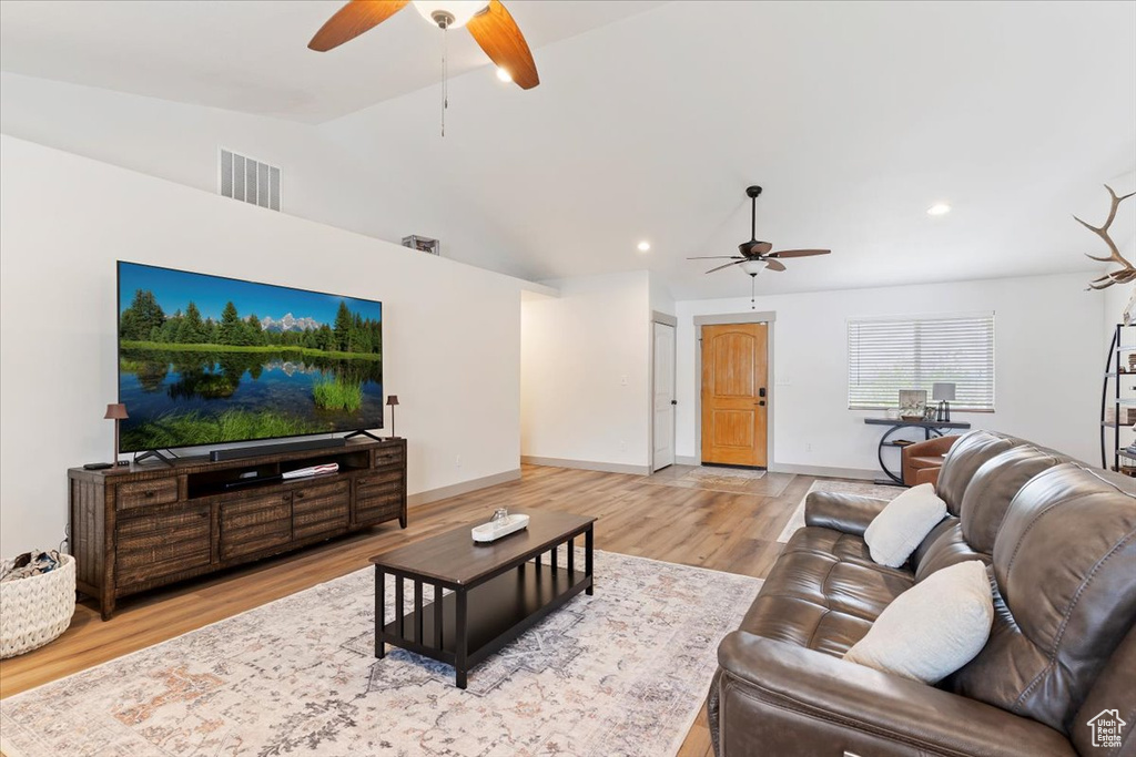 Living area featuring a ceiling fan, vaulted ceiling, wood finished floors, baseboards, and recessed lighting