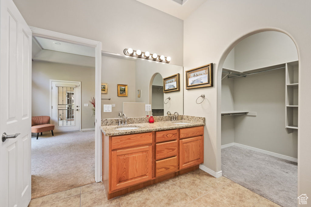 Full bath with tile patterned flooring, double vanity, and baseboards