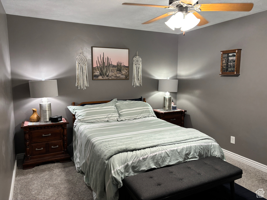 Carpeted bedroom with baseboards and a ceiling fan