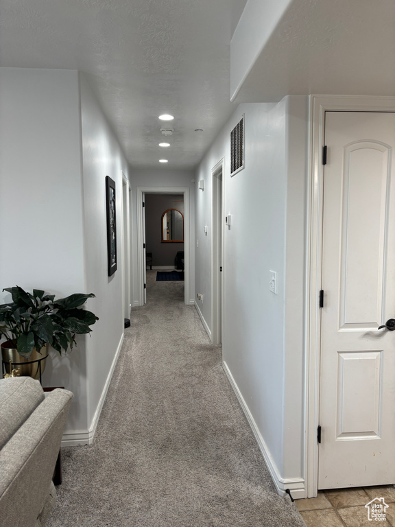 Hallway with baseboards, light carpet, and recessed lighting