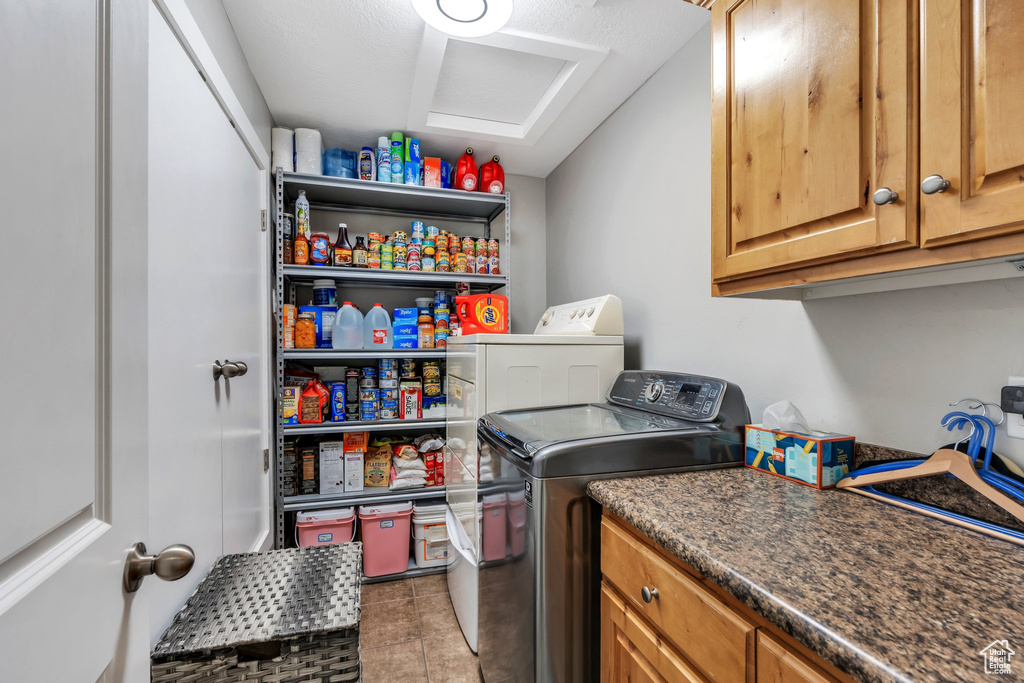 Washroom with separate washer and dryer, tile patterned floors, cabinet space, and attic access