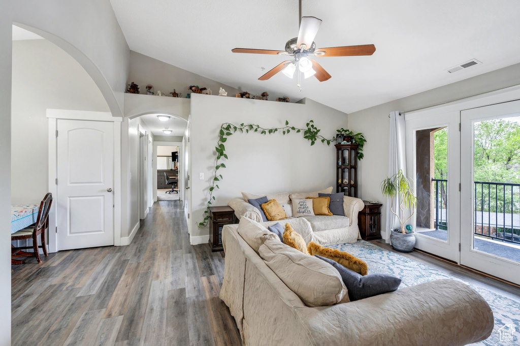 Living room with arched walkways, ceiling fan, wood finished floors, lofted ceiling, and baseboards