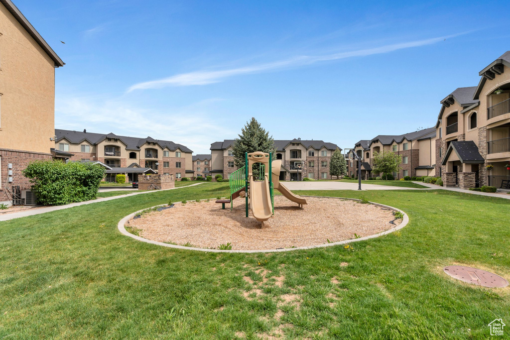 Communal playground featuring a residential view and a lawn