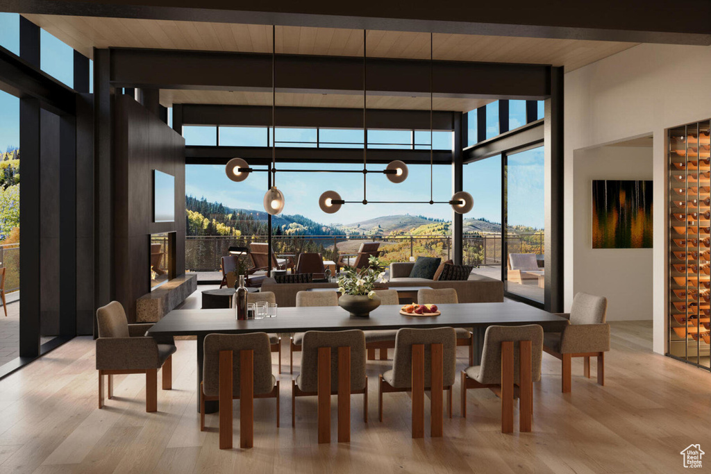 Dining space featuring floor to ceiling windows, wood finished floors, healthy amount of natural light, beamed ceiling, and a chandelier