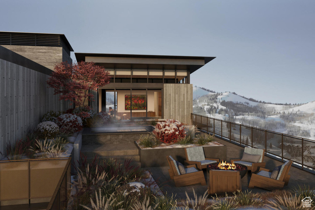 View of patio with a mountain view and a fire pit