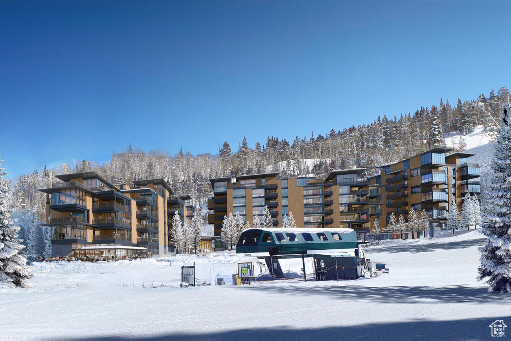 Snow covered building featuring a view of apartment building / complex