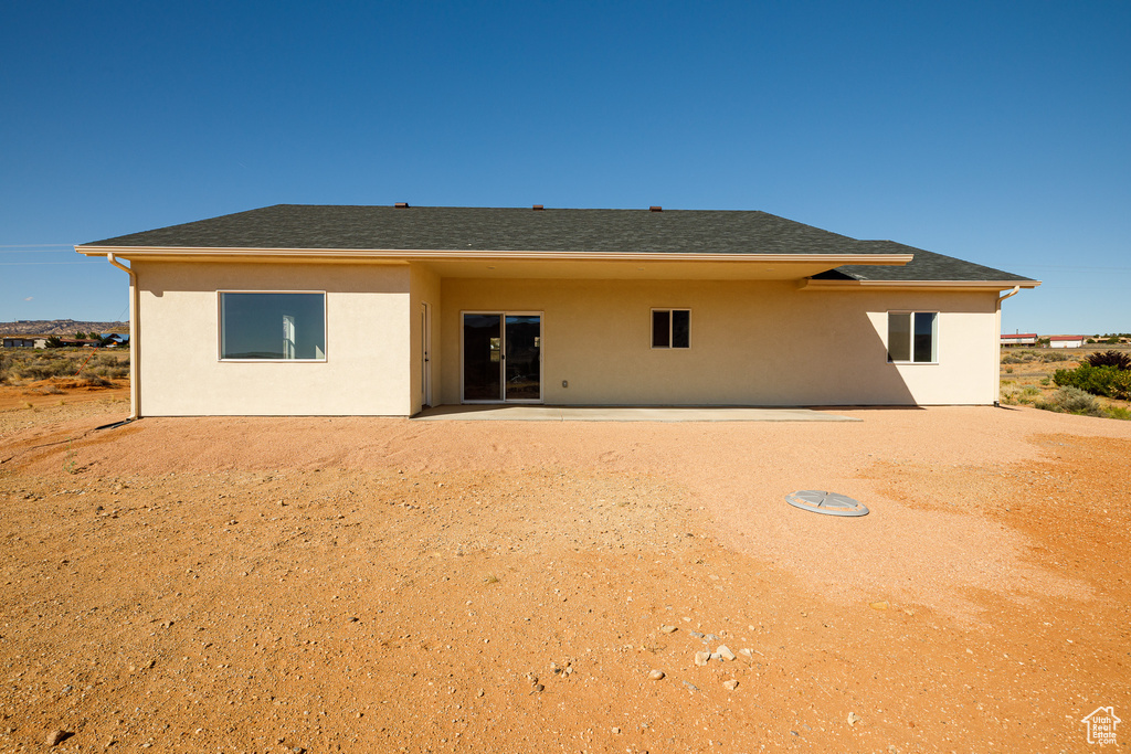 Back of property featuring stucco siding and a shingled roof