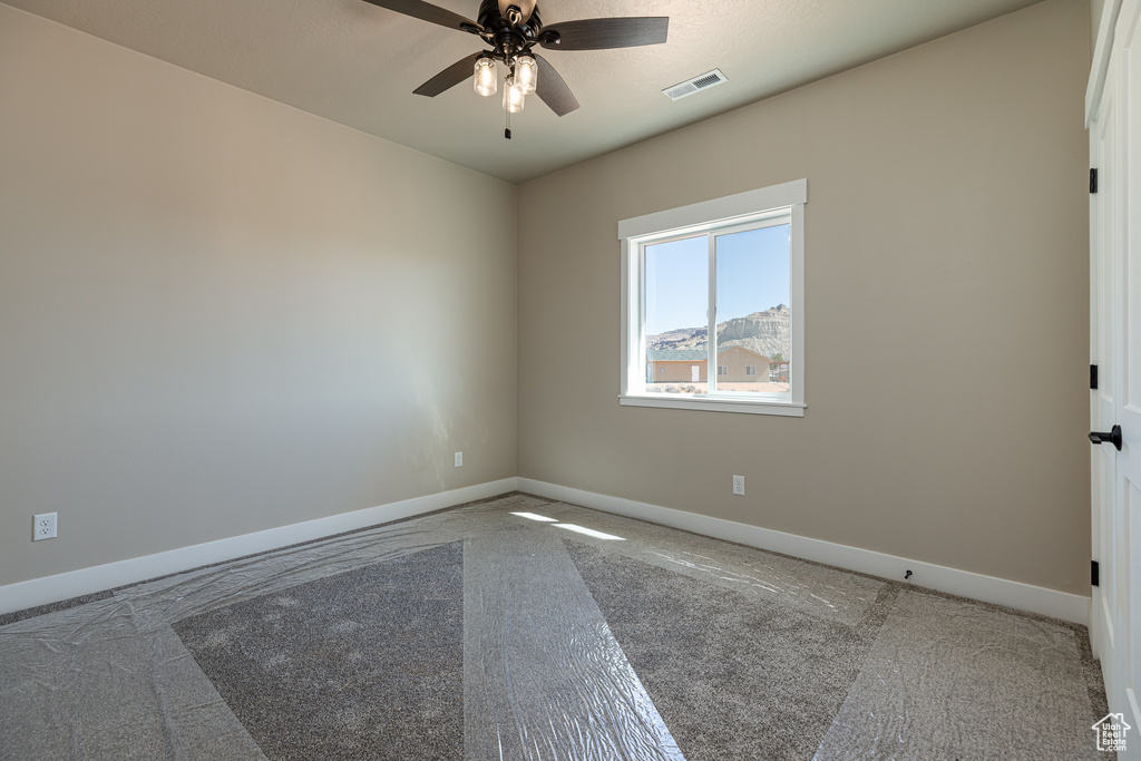 Unfurnished room with carpet flooring, baseboards, and a ceiling fan