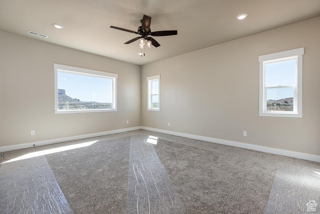 Carpeted empty room with ceiling fan, baseboards, and recessed lighting