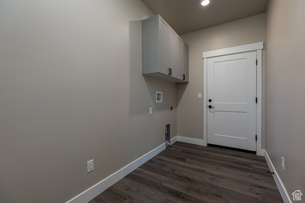 Laundry room featuring washer hookup, dark wood-style floors, electric dryer hookup, cabinet space, and baseboards