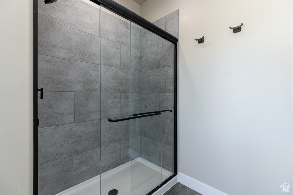 Bathroom featuring a shower stall and baseboards