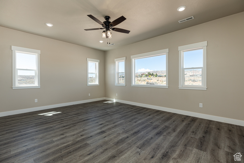 Spare room featuring dark wood-style floors, baseboards, ceiling fan, and recessed lighting