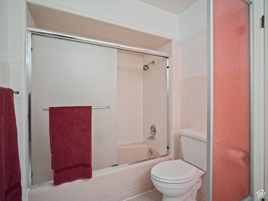 Full bathroom with toilet and enclosed tub / shower combo