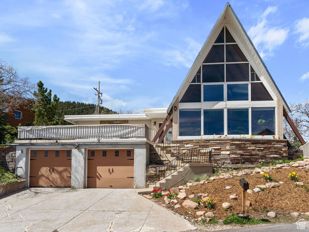 View of front of property featuring concrete driveway and an attached garage