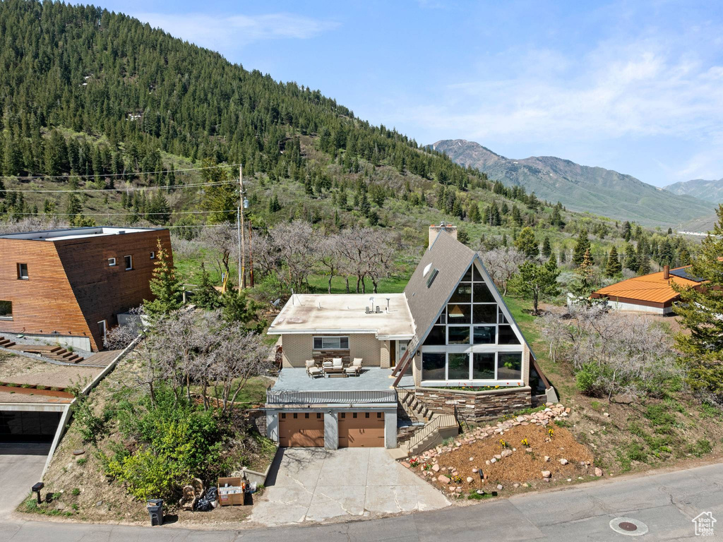 View of subject property featuring a forest and a mountainous background