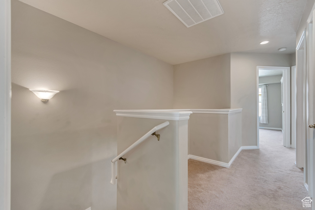 Corridor featuring light carpet, an upstairs landing, baseboards, and recessed lighting
