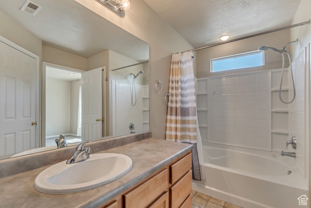 Full bath with shower / bath combination with curtain, vanity, a textured ceiling, and tile patterned flooring