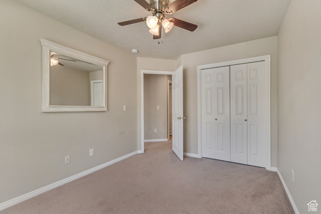 Unfurnished bedroom with carpet flooring, baseboards, a closet, and ceiling fan