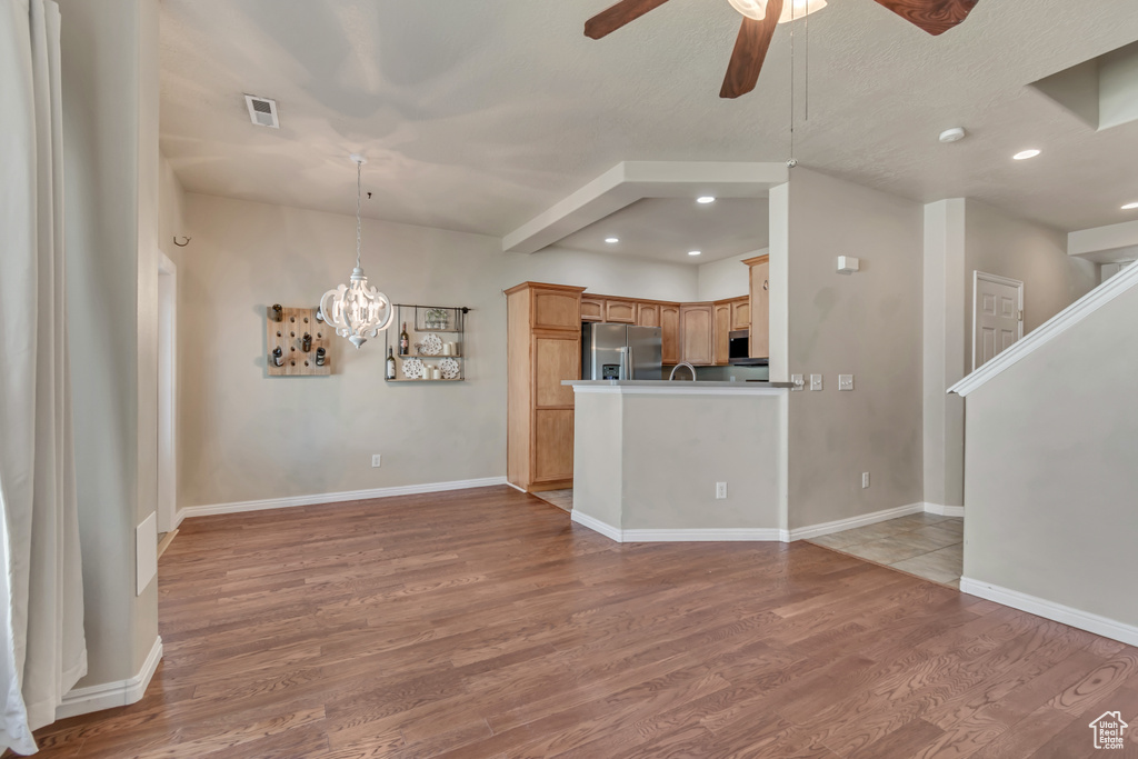 Unfurnished living room featuring ceiling fan, light wood finished floors, recessed lighting, a chandelier, and baseboards