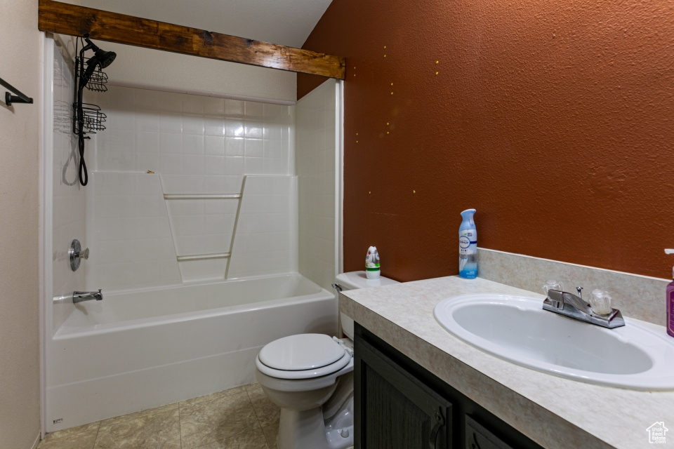Full bath with toilet, vanity, shower / bath combination, and a textured wall
