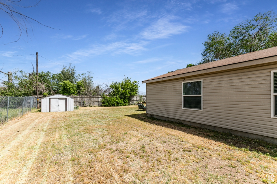 View of yard with a storage shed and an outdoor structure