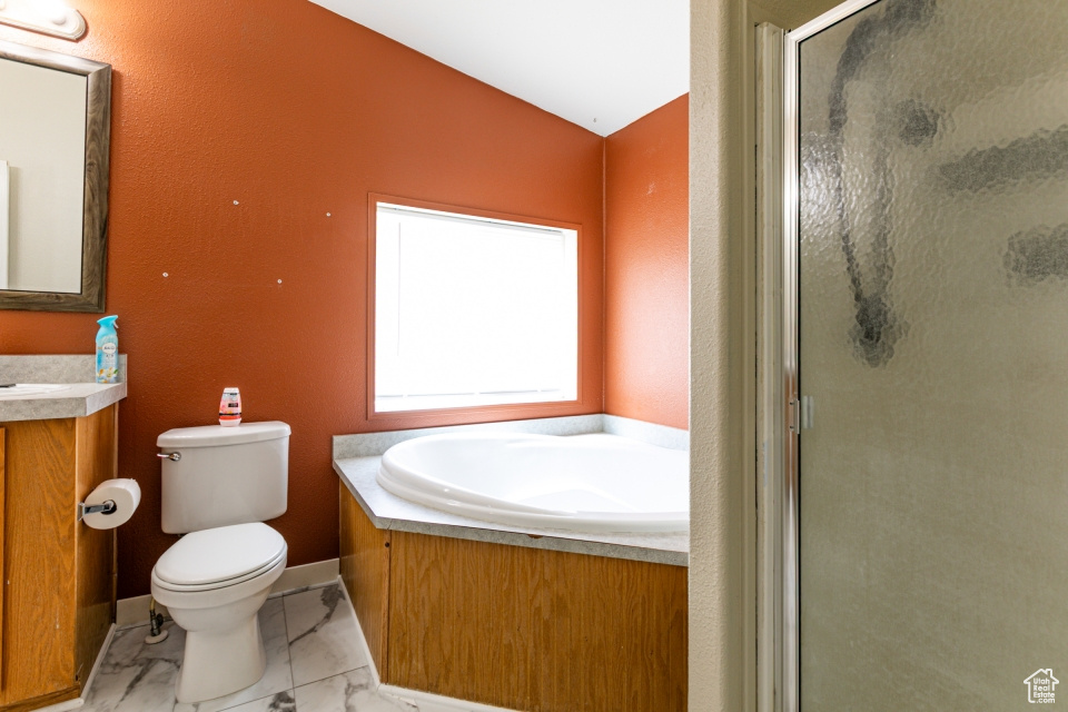 Bathroom with marble look tile flooring, a stall shower, toilet, vanity, and vaulted ceiling