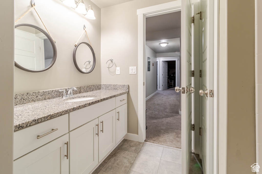 Bathroom with vanity, baseboards, and tile patterned floors