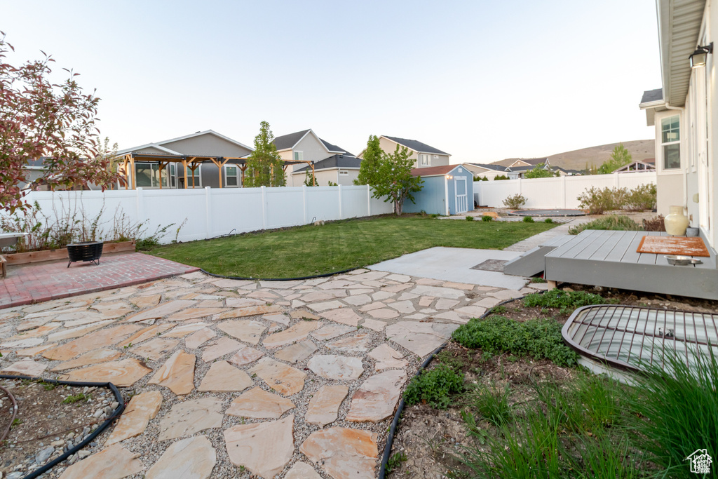 View of yard featuring a shed, a patio, an outbuilding, and a deck