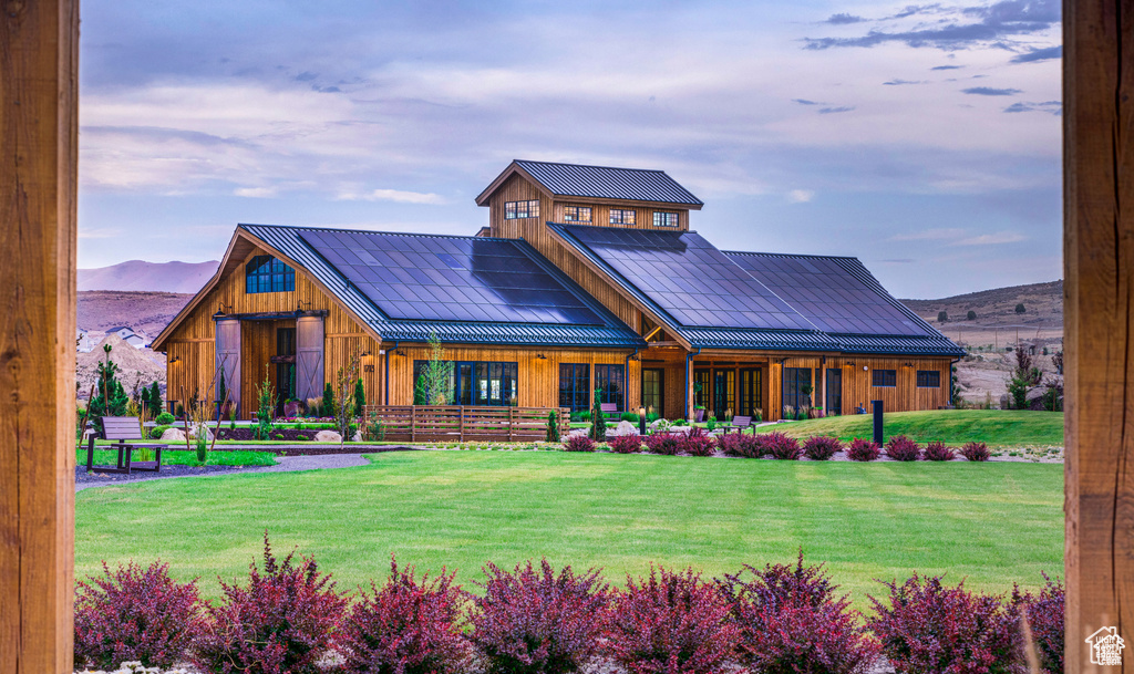 View of front of property featuring a standing seam roof, a mountain view, a front yard, metal roof, and board and batten siding