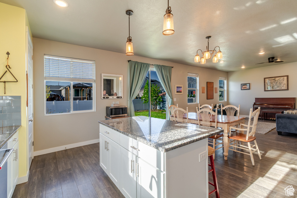 Kitchen featuring stainless steel microwave, a center island, dark wood-style floors, recessed lighting, and a chandelier