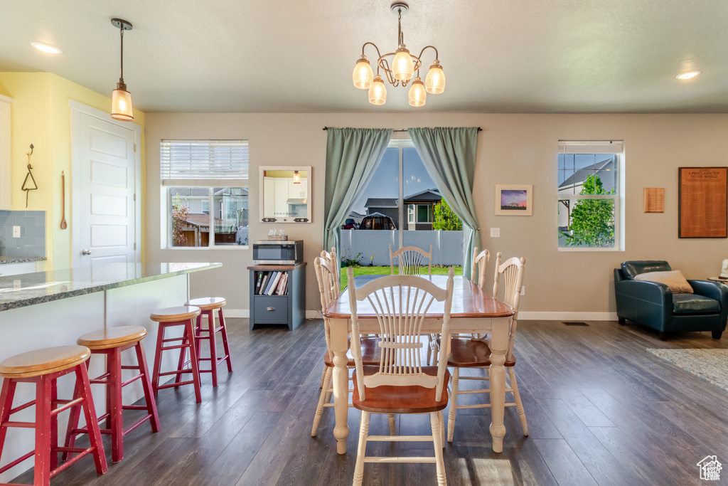Dining room featuring plenty of natural light, baseboards, dark wood-style flooring, and recessed lighting
