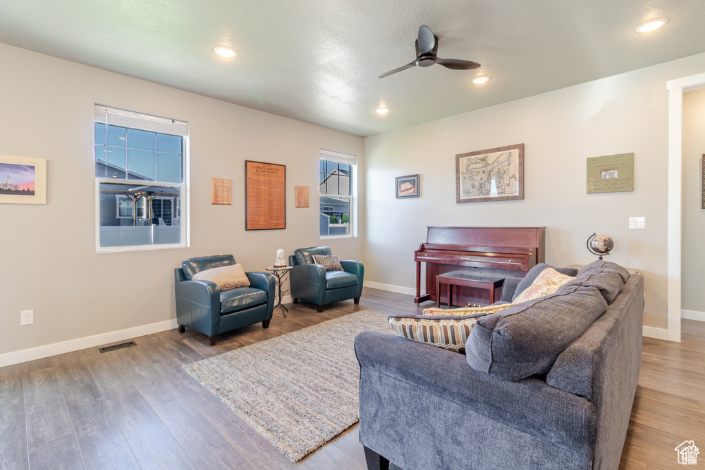 Living area featuring ceiling fan, wood finished floors, baseboards, and recessed lighting
