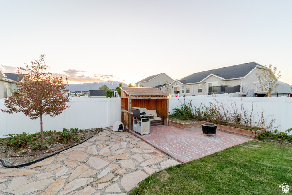 Patio terrace at dusk featuring a storage shed and an outdoor structure