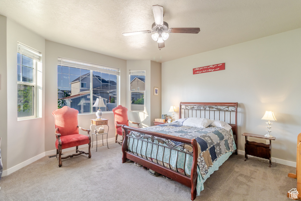 Bedroom featuring carpet, baseboards, a ceiling fan, and a textured ceiling