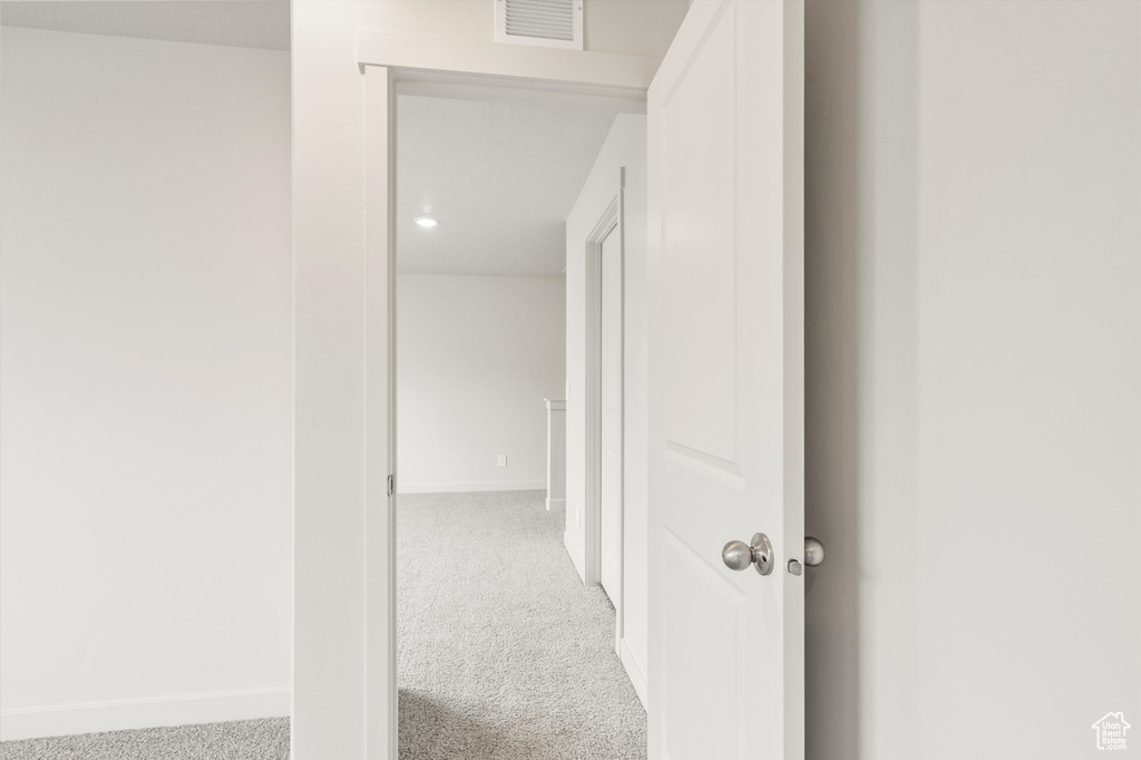 Corridor featuring carpet flooring and baseboards