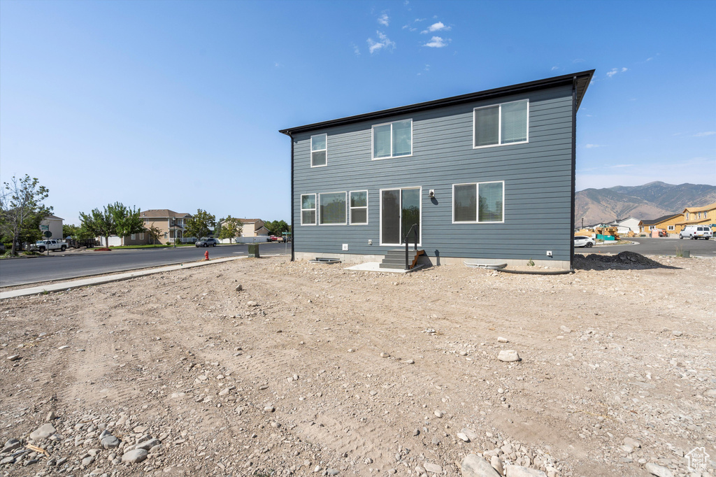 Back of property featuring a mountain view and entry steps