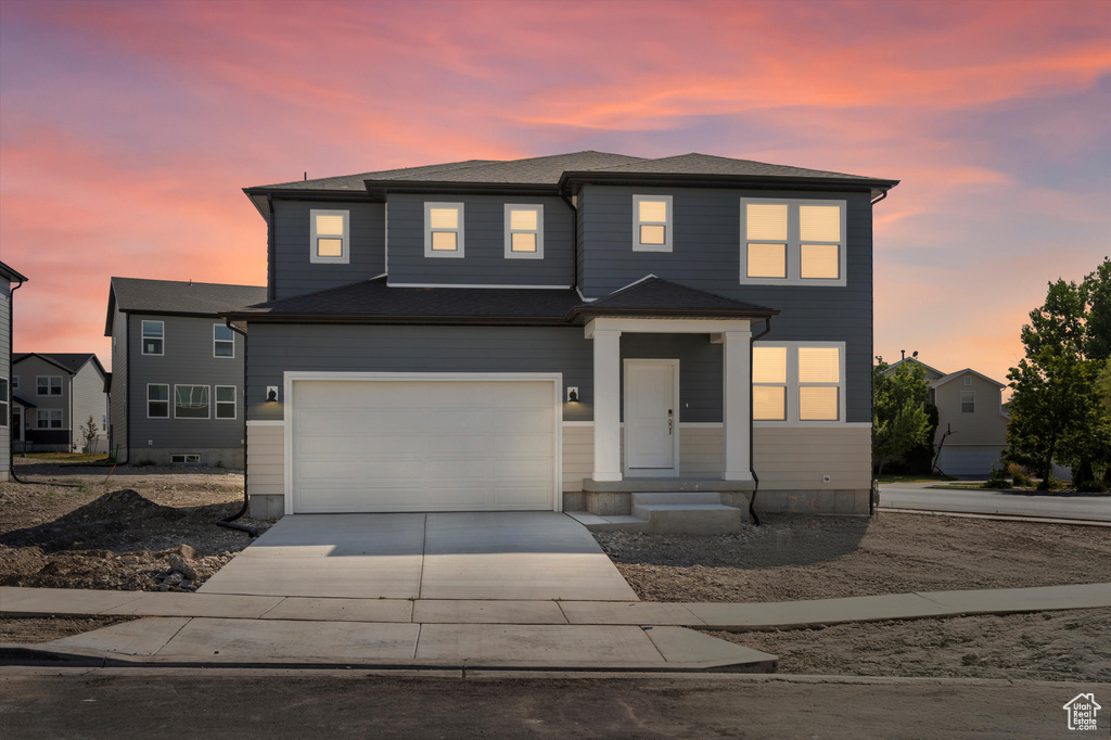 View of front facade featuring concrete driveway and a garage