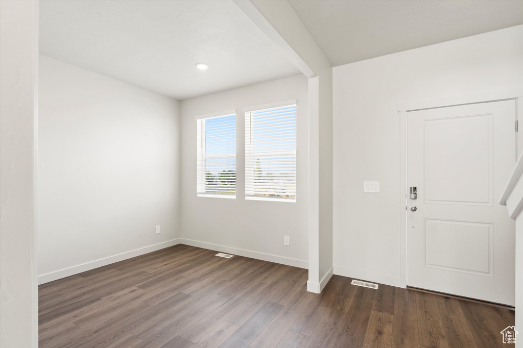 Foyer with dark wood-type flooring and baseboards