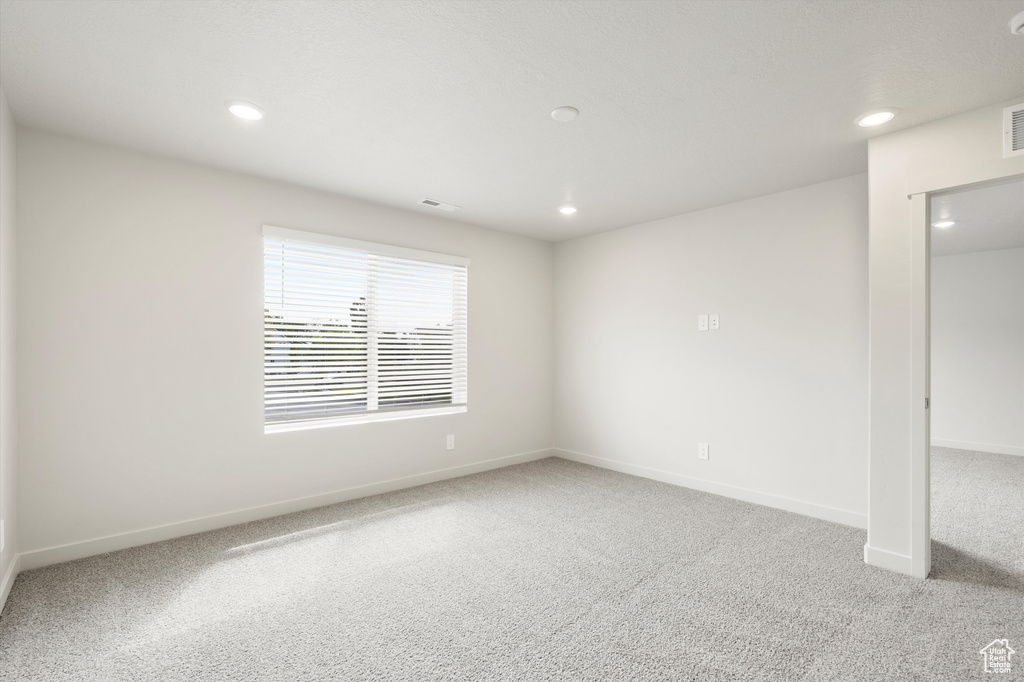 Carpeted spare room featuring baseboards and recessed lighting