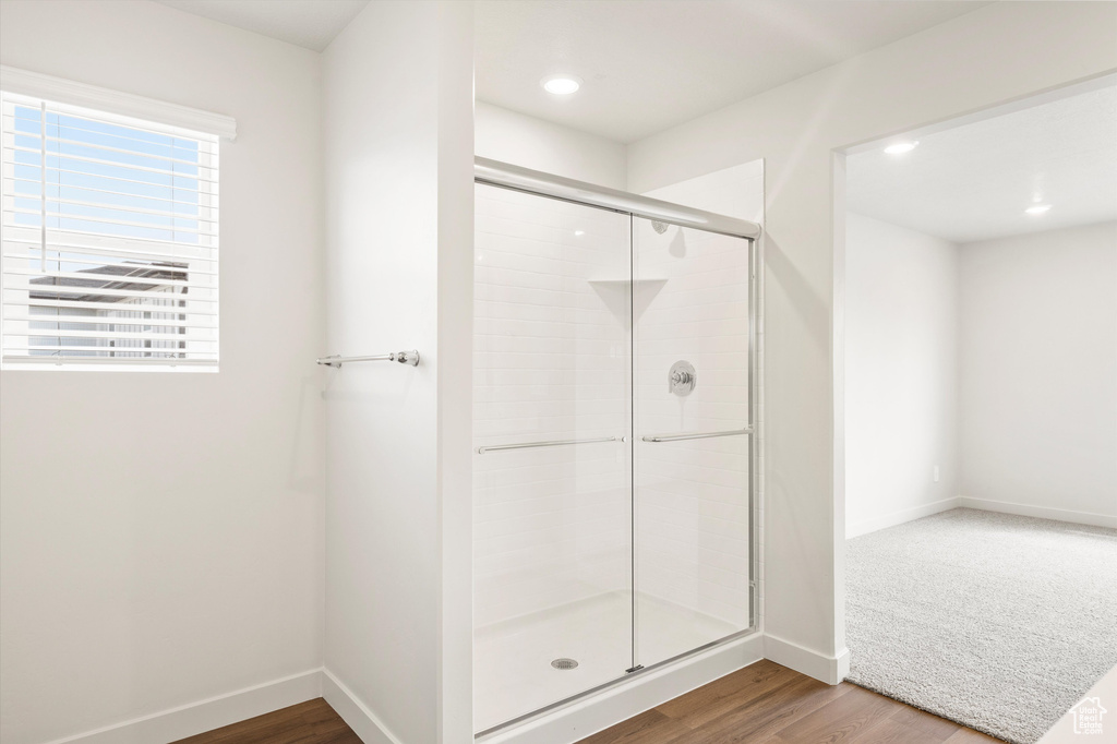 Bathroom with a stall shower, wood finished floors, and recessed lighting